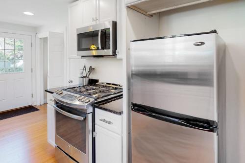 a kitchen with a stainless steel refrigerator and a stove at Belmont Beach Cottage in West Harwich