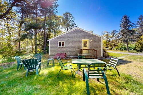 a group of chairs and a table in the grass at Belmont Beach Cottage in West Harwich