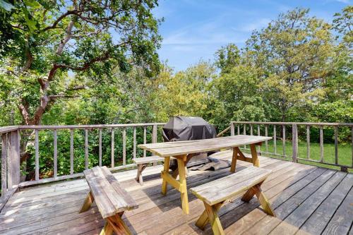 a wooden deck with a picnic table and an umbrella at Sandpiper's Saltbox in Dennis