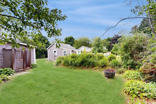 a yard with a house and a fence at Cozy Escape on the Cape in Eastham