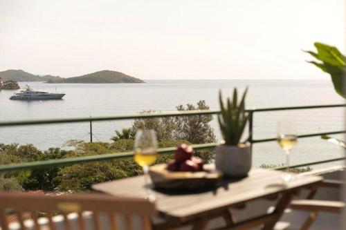 a table with wine glasses and a view of the water at Nimfi Hotel, Skiathos in Megali Ammos