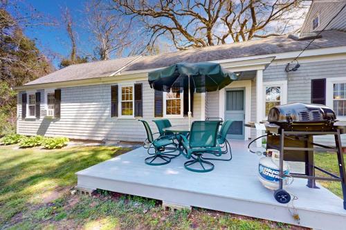 a patio with a grill and chairs and a table and chairs at Gray Gables in Orleans