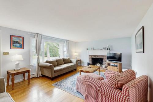 a living room with two couches and a fireplace at Captain's Escape in South Yarmouth