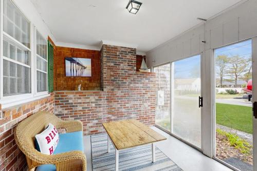 a patio with a table and chairs and a brick wall at Captain's Escape in South Yarmouth