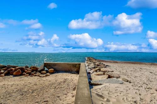 a retaining wall on a beach with the ocean at Seabreeze Escape in Falmouth
