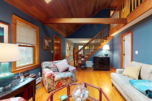 a living room with a white couch and a staircase at Need a Bigger Boat in Edgartown