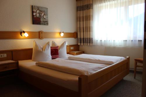a hotel room with two beds and a window at Appartements Eggenhofer in Sankt Jakob in Defereggen