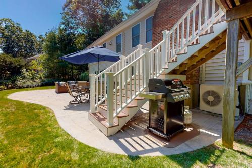 a patio with a grill next to a house at Osterville Odyssey in Osterville
