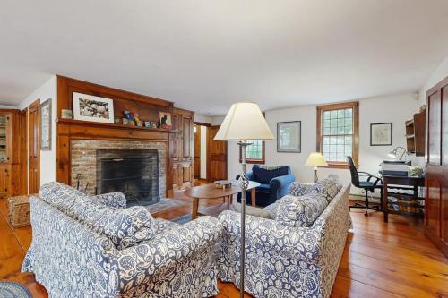 a living room with two couches and a fireplace at Sheep Pond Bow House in Brewster