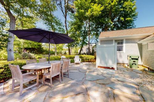 a patio with a table and chairs and an umbrella at Cape River Retreat in Centerville