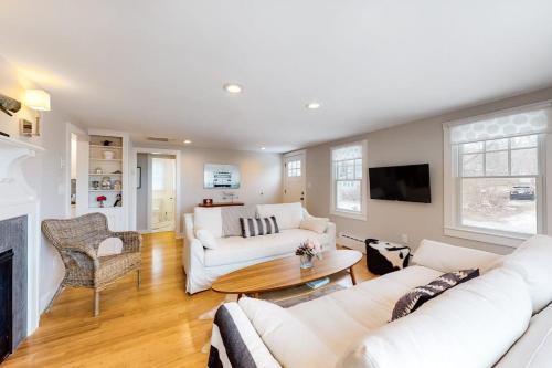 a living room with white furniture and a fireplace at Island Home in Vineyard Haven