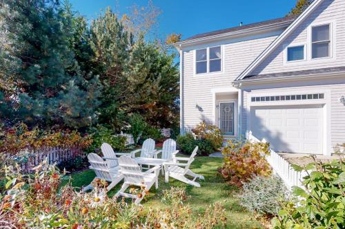 a yard with a table and chairs in front of a house at Modern Beach & Town Getaway in Falmouth