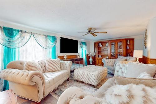 a living room with white furniture and blue curtains at Coastal Charm on the Cape in Centerville