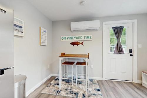 a kitchen with a stool and a fish sign on the wall at Garage Suite in Oak Bluffs