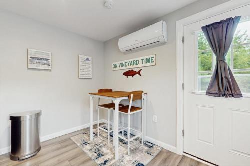 a small white room with a table and a window at Garage Suite in Oak Bluffs