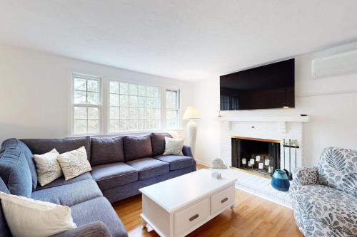 a living room with a blue couch and a fireplace at Seabreeze in Dennis Port