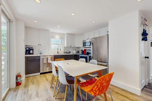 a kitchen with a table and chairs and a refrigerator at The Grey Lady in Provincetown
