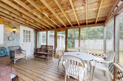 a screened in porch with a table and chairs at Gingerbread Dream in Oak Bluffs