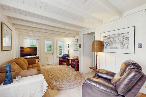a living room with a leather chair and a couch at Gingerbread Dream in Oak Bluffs
