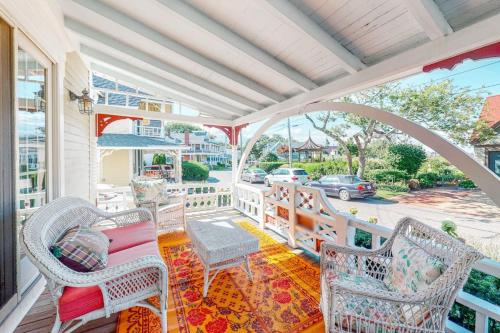 a porch with wicker chairs and a table at Island Dream in Oak Bluffs