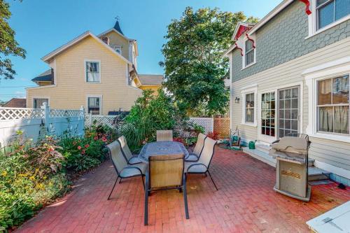 a patio with a table and chairs and a house at Island Dream in Oak Bluffs