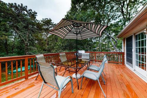 a patio with a table and chairs and an umbrella at Summer Daze in Edgartown