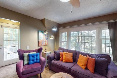 a living room with a purple couch and two chairs at Provincetown Bliss in Provincetown
