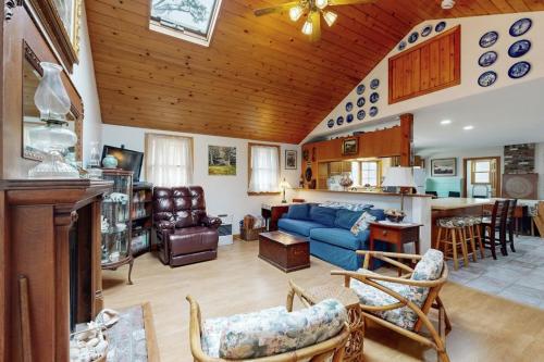 a living room with a blue couch and a kitchen at C-Haven in West Tisbury