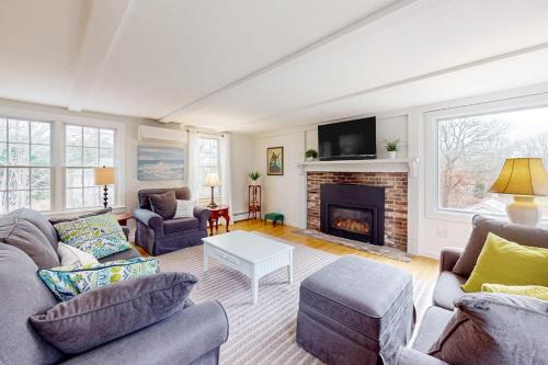 a living room with two couches and a fireplace at Saltwater Haven in Orleans