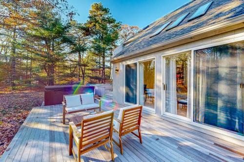 a patio with two chairs and a bench on a deck at Tiffany's Treasure in Oak Bluffs