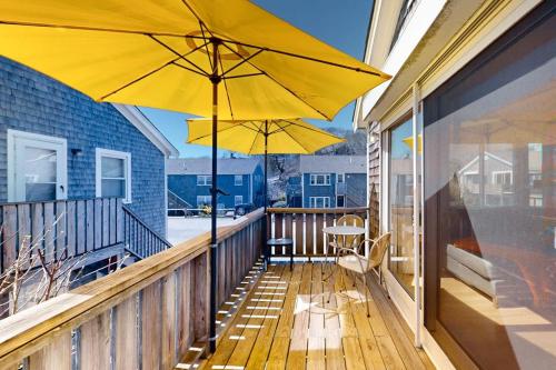 a balcony with two yellow umbrellas on a house at Beach Blessing in Provincetown