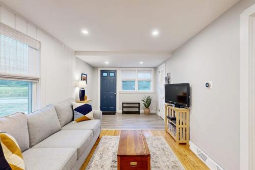 a living room with a couch and a tv at Seabreeze Escape in Barnstable