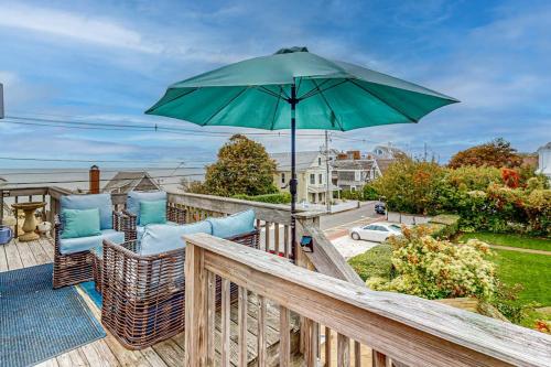 a patio with chairs and an umbrella on a deck at Bayview Bliss in Provincetown