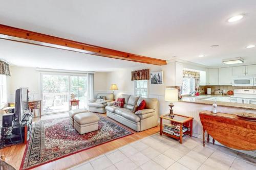 a living room with a couch and a kitchen at Falmouth Beachtown Getaway in Falmouth