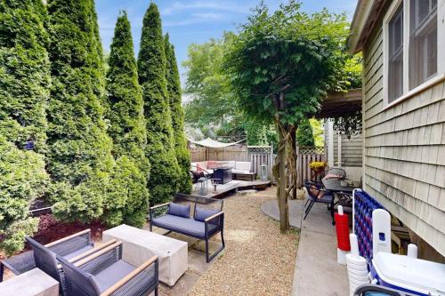 a patio with chairs and tables and a tree at Sankofa Martha's Vineyard in Oak Bluffs