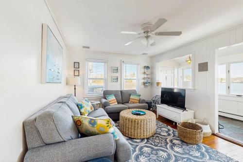 a living room with a couch and a tv at SEA-esta in Falmouth