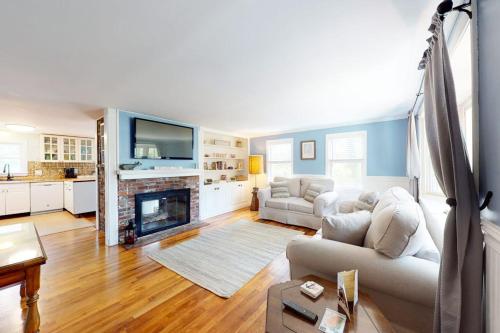 a living room with a couch and a fireplace at Meet Me at the Cape in Barnstable