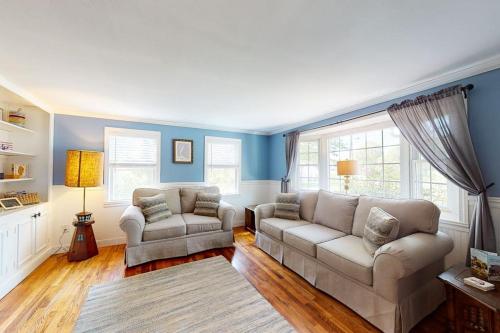 a living room with two couches and blue walls at Meet Me at the Cape in Barnstable