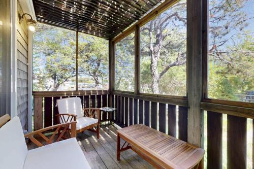 a screened in porch with a bench and windows at Endless Summer in Provincetown