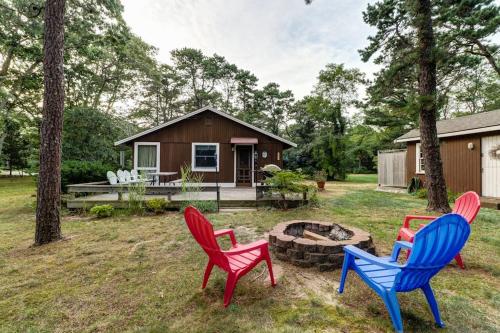 three chairs sitting around a fire pit in front of a house at Eastham Escape in North Eastham