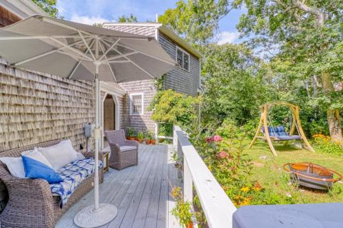 a patio with an umbrella and a swing at Island Oasis in Edgartown