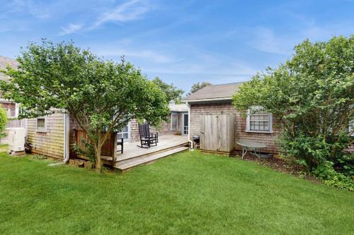 a house with a deck and a yard at Little Cozy Corner in Edgartown