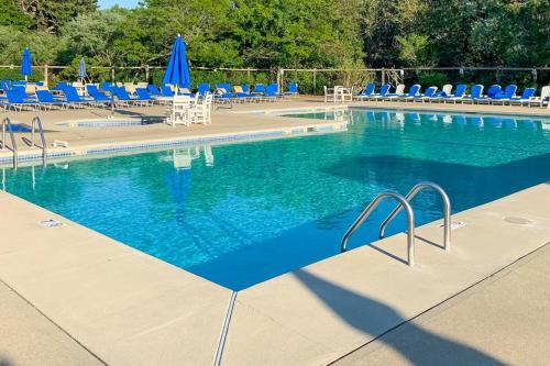 ein großes Schwimmbecken mit blauen Liegestühlen und blauen Sonnenschirmen in der Unterkunft Ocean Mandevilla in Brewster