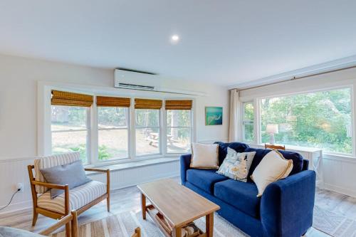 a living room with a blue couch and windows at Sea House in Chatham