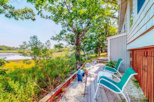 a porch with two green and white chairs on it at Cottage by the Bay in Pocasset