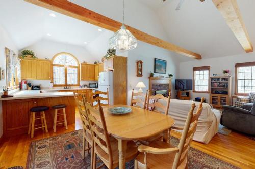 a kitchen and living room with a table and a couch at The Tranquil Heron Cottage in Eastham