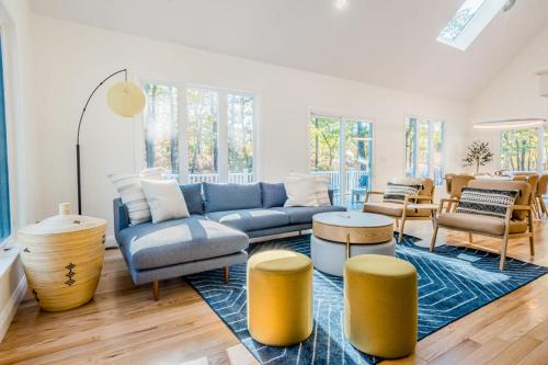 a living room with a blue couch and yellow stools at Peace Among the Pines in Wellfleet