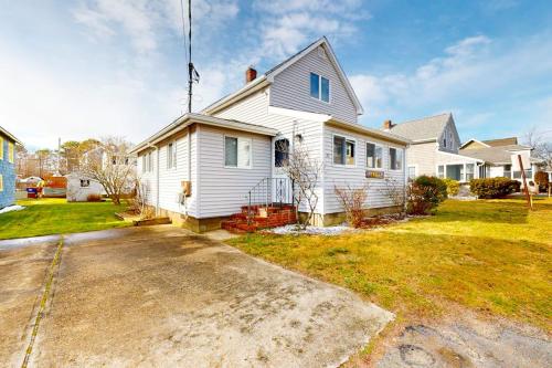 a white house with a driveway in a yard at Swift Beach House in Wareham