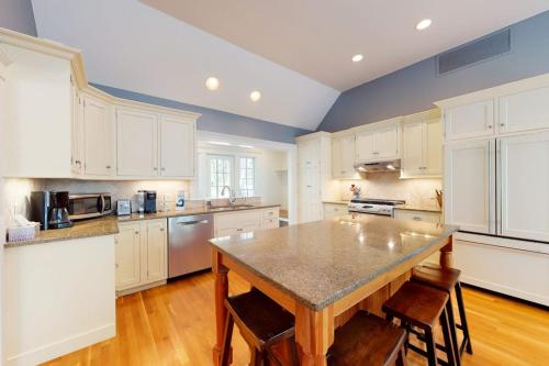 a kitchen with white cabinets and a table with chairs at Spinnaker Trail in Orleans