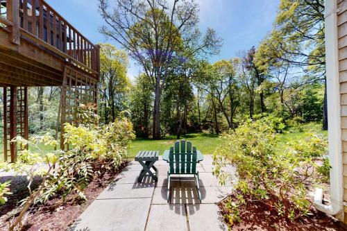 two green chairs sitting on a sidewalk in a garden at Spinnaker Trail in Orleans